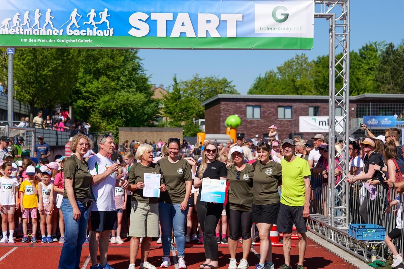 Foto von der Bürgermeisterin und Helfern unter dem Starterbogen des Bachlaufs.
