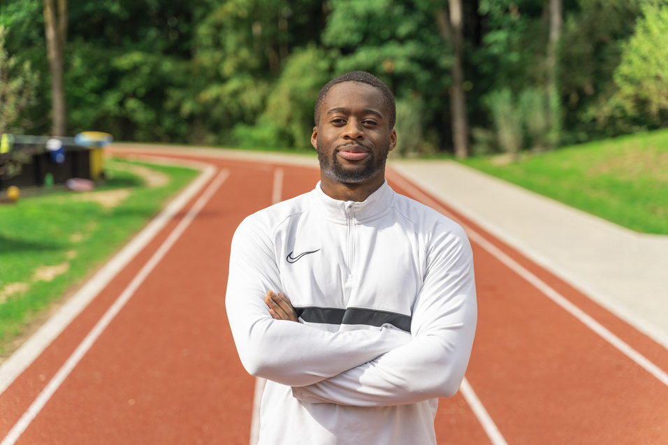 Hier sieht man unseren neuen Übungsleiter im Profil auf einer Laufbahn stehen.
