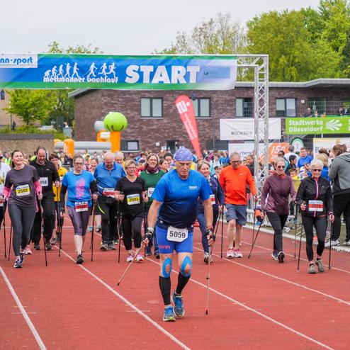 Teilnehmer mit Nordic-Walking-Stöcken starten beim Laufereignis unter dem "START"-Schild in Mettmann.