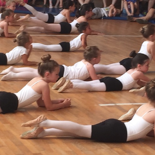 Gruppe von jungen Balletttänzerinnen in Fitnesskleidung, lying auf dem Boden in einer Tanzaufführung.