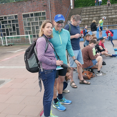 Ein Mann und eine Frau stehen gemeinsam an einem Touchausschuss, umgeben von weiteren Personen im Freien.