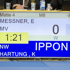 Digitalanzeige eines Judo-Wettkampfs mit den Namen Messner und Hartung, Punktestand und Zeit: 1:21, Ippon für Hartung.