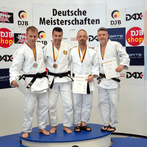 Vier Sportler in Judogis mit Medaillen und Urkunden stehen auf einem Podium bei den Deutschen Meisterschaften.