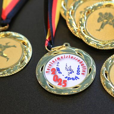 Goldmedaillen mit Judo-Motiven und bunten Bändern, beschriftet mit „Vereinsmeisterschaften 2025“.