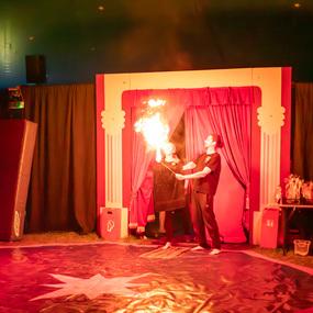 Feuerakrobatik-Performance in einem Zirkuszelt mit Künstlern und brennenden Flammen auf der Bühne.