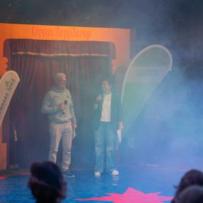 Zwei Moderatoren stehen auf einer Bühne vor einem Vorhang, umgeben von Nebel, bei der Veranstaltung im Circus ZappZarap.