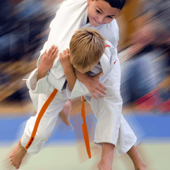 Zwei Kinder im Judoanzug zeigen einen Wurf im Judo, während sie auf einer Matte trainieren.