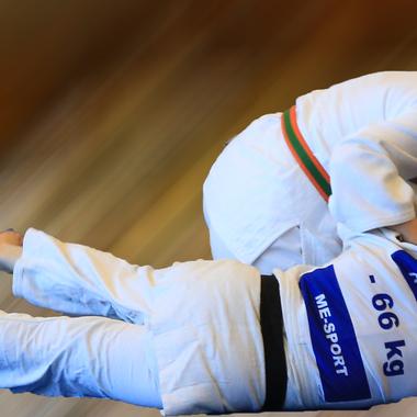 Zwei Judoka im Wettkampf, eine Athletin h&auml;lt ihren Gegner, beide tragen wei&szlig;es Judogi.