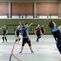 Jugendliche Volleyballspieler in Aktion, Ballwechsel während eines Spiels in einer Sporthalle.