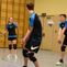 Drei Volleyballspieler in action, einer empfängt den Ball, während die anderen sich auf das Spiel vorbereiten.