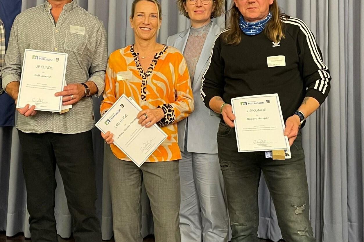 Gruppenfoto von drei ehrenamtlichen Personen die mit der Bürgermeisterin und Urkunden posieren.