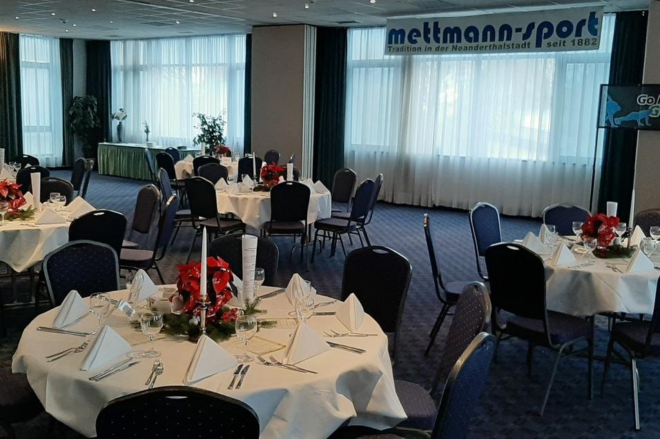 Vier gedeckte Tische zum Jahresabschluss der alten Herren im Hotel Wynham in Mettmann. Die Tische sind mit weißen Tischdecken und rotem Blumenschmuck geschmückt.