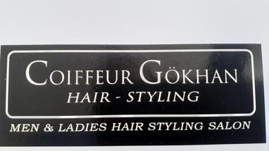Schwarze Visitenkarte mit dem Text „Coiffeur Gökhan Hair-Styling Men & Ladies Hair Styling Salon“.