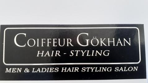Schwarze Visitenkarte mit dem Text „Coiffeur Gökhan Hair-Styling Men & Ladies Hair Styling Salon“.