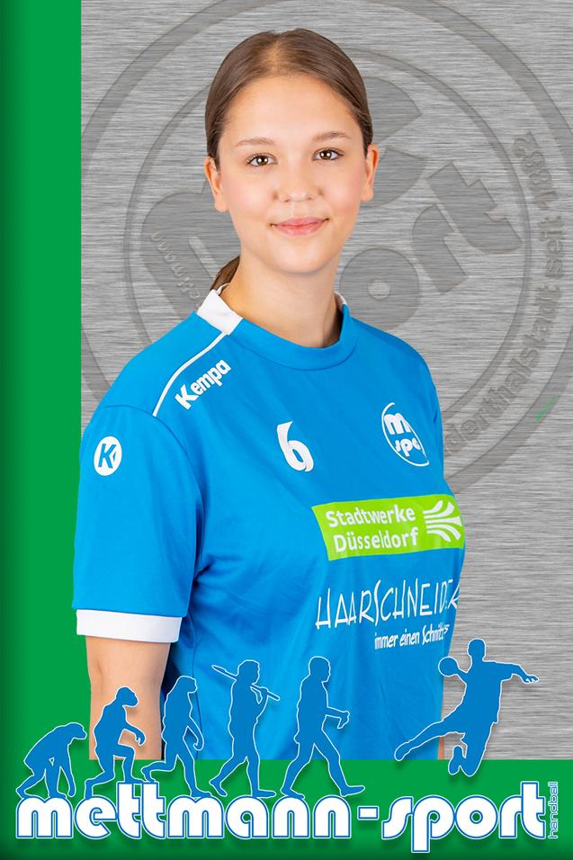 Porträt einer lächelnden Sportlerin in einem blauen Handballtrikot mit Sponsorenlogos vor grauem Hintergrund.