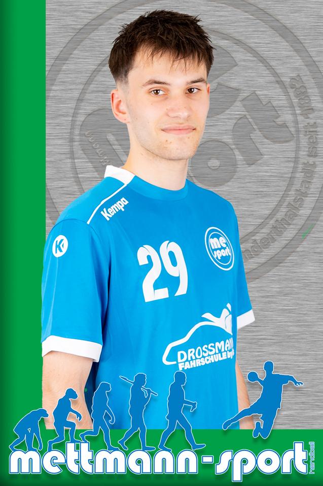 Porträt eines lächelnden jungen Mannes in blauer Sportkleidung mit der Nummer 29 vor einem grauen Hintergrund.