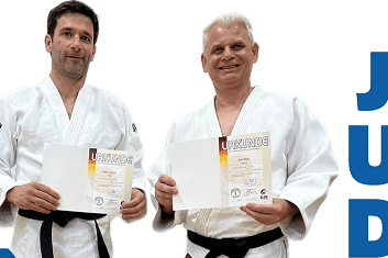 Zwei Judoka in wei&szlig;en Anz&uuml;gen halten Urkunden in der Hand und stehen nebeneinander. Text auf dem Bild: "JUDO".