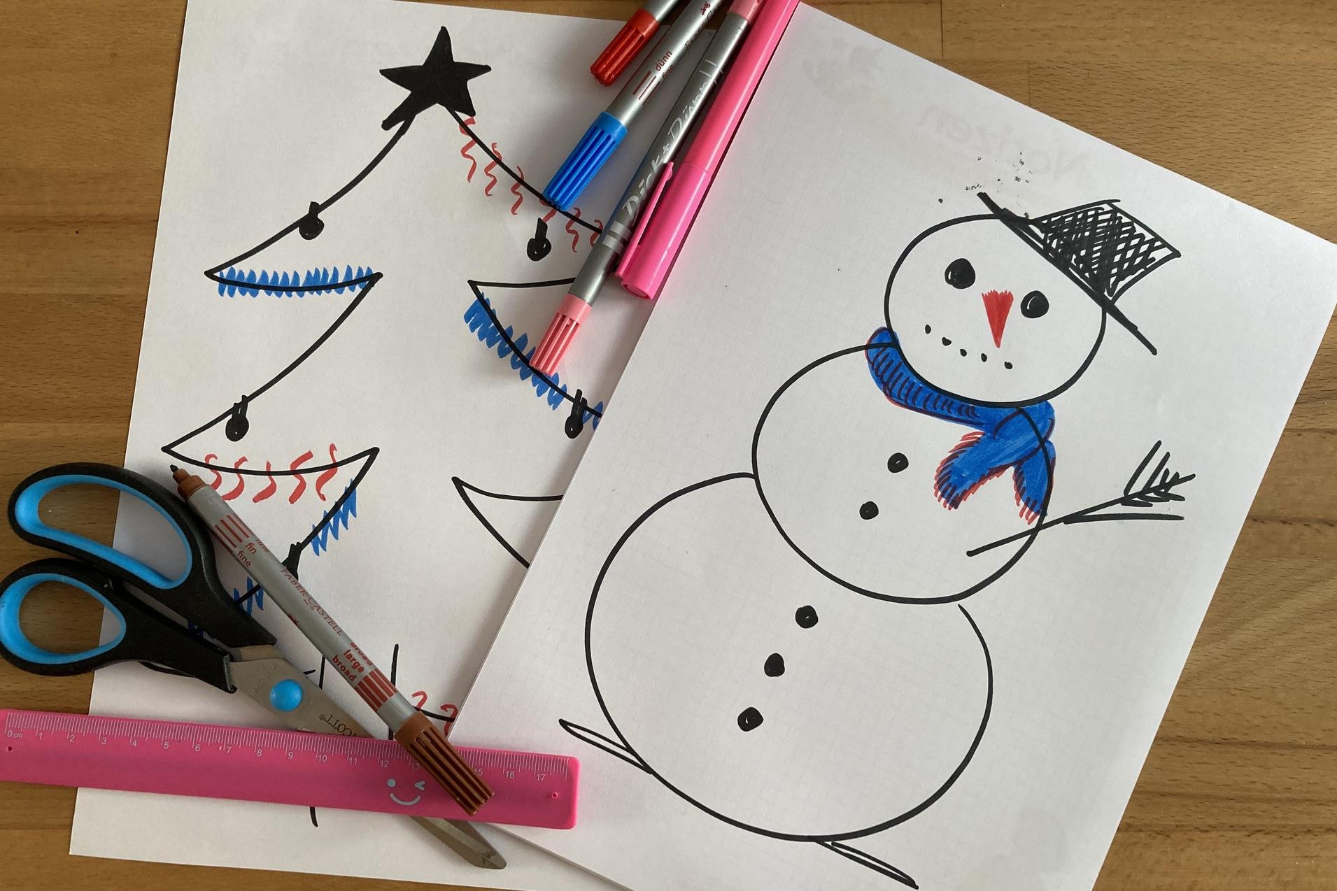 Zwei gemalte Bilder: ein Weihnachtsbaum und ein Schneemann, umgeben von Schere und bunten Markern auf einem Tisch.
