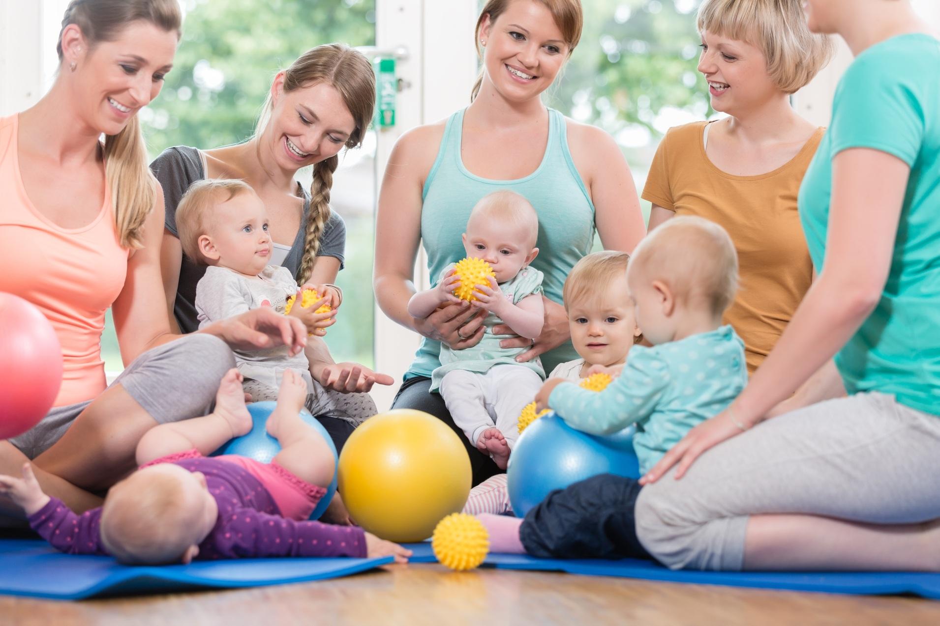 Babys mit Eltern die mit dem Ball spielen