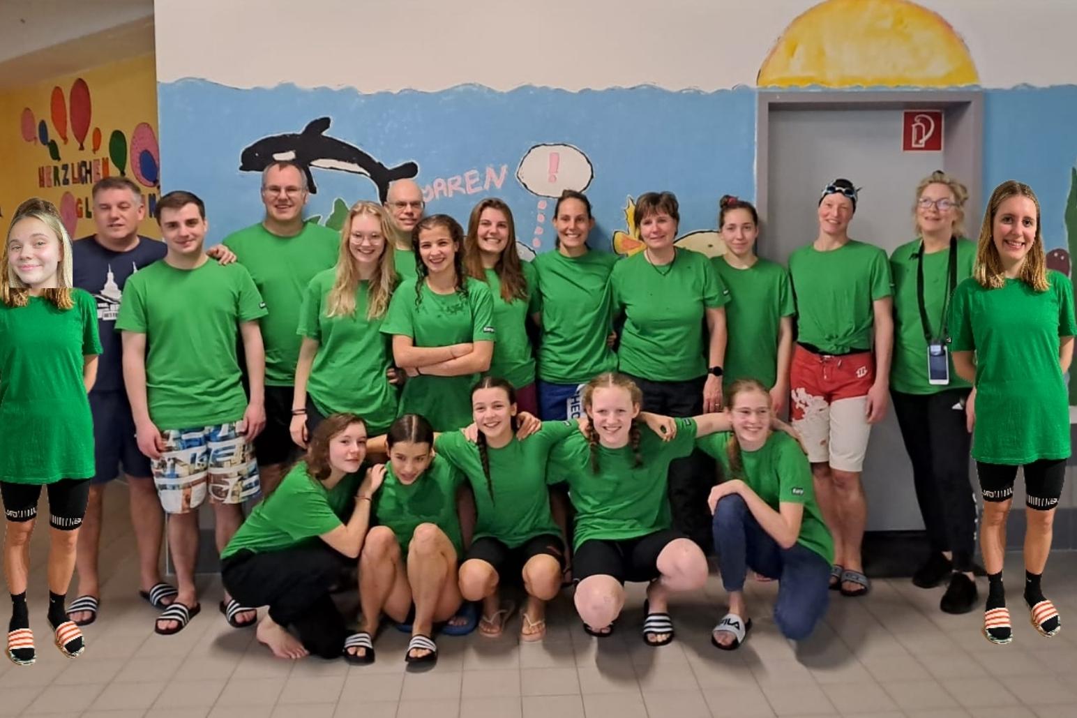 Gruppe von Jugendlichen in grünen T-Shirts und Shorts, posierend vor einer bunten Wandmalerei in einem Gemeinschaftsraum.