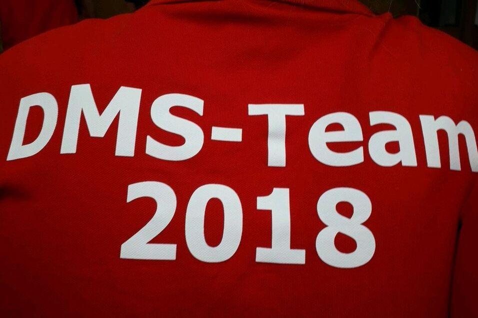 Roter Mannschaftsjersey mit der Aufschrift „DMS-Team 2018“ in großen weißen Buchstaben.