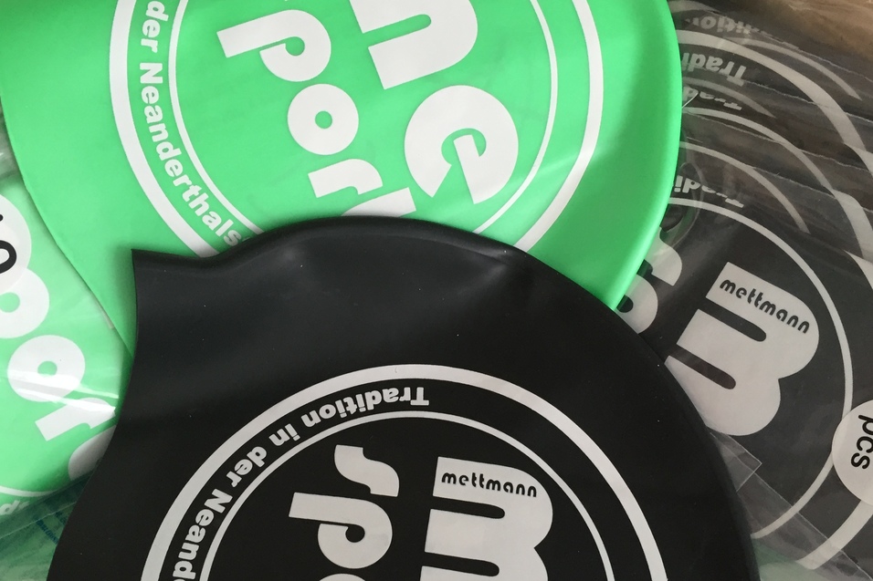 Schwimmkappen in Grün und Schwarz mit Hinweis auf 10 Stück, verpackt in einer Box.