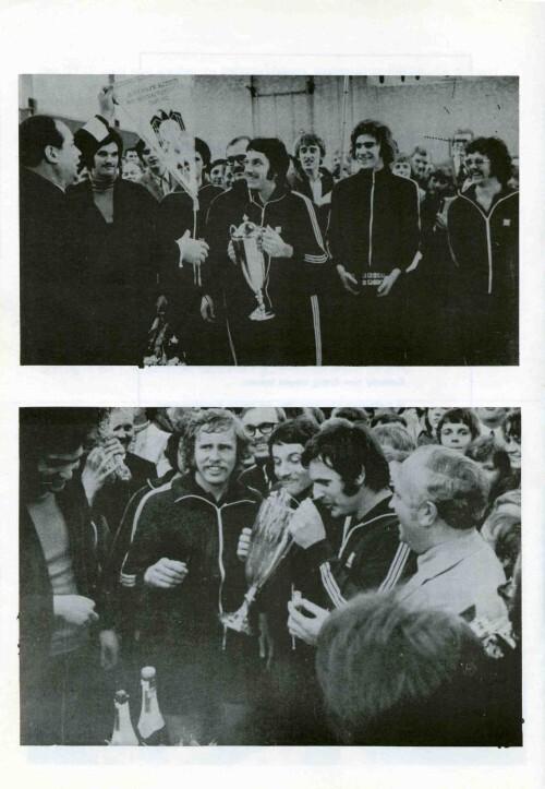 Gruppenszene mit sportlichen Männern in Trainingsanzügen, die eine Trophäe halten und mit Zuschauern feiern.