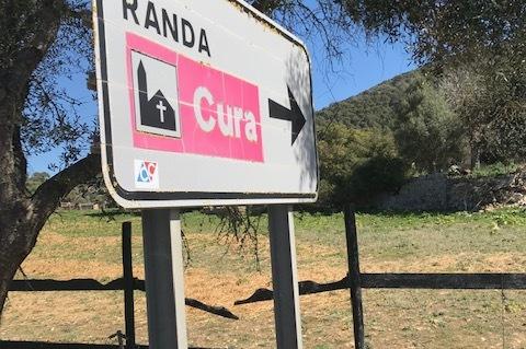 Wegweiser nach Randa mit Richtungspfeil nach rechts, Hintergrund zeigt eine ländliche Landschaft mit Bäumen.