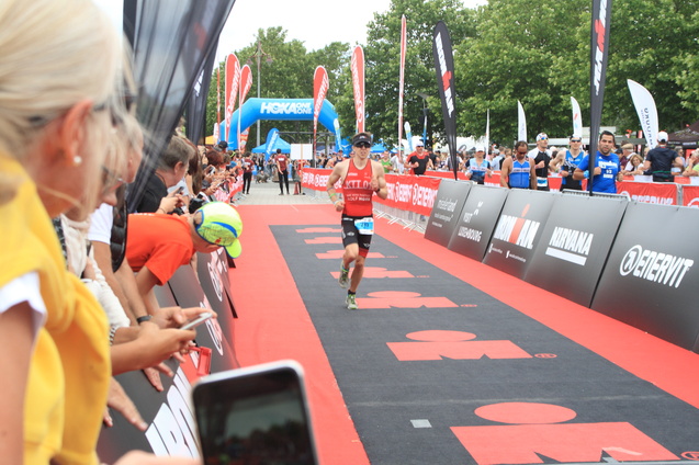 Ein Athlet mit Startnummer 798 sprintet auf die Ziellinie eines Triathlon-Events, umgeben von jubelnden Zuschauern.