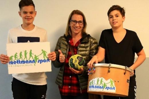 Steffi aus dem Vorstand des Fördervereins übergibt die neue Trommel zwei Jugendlichen aus der Handball Abteilung.