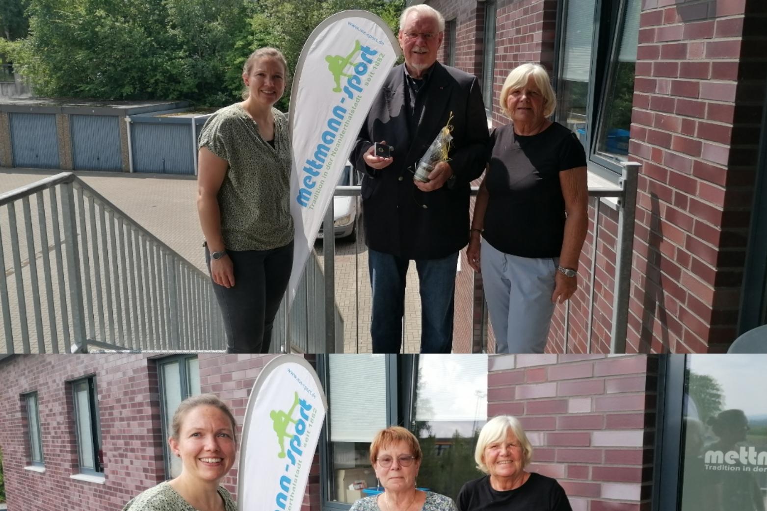 Zwei Gruppen von Personen posieren vor einem Geb&auml;ude mit einem Fahnenmast und einer Auszeichnung in den H&auml;nden.