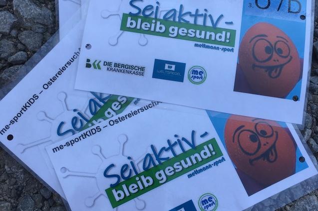 Stapels von Informationsblättern mit dem Text „Sei aktiv – bleib gesund!“ und einer gezeichneten Ei-Figur.