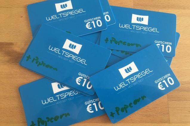 Stapel blauer Gutscheinkarten des Kinos „Weltspiegel“ mit Werten von 10 Euro, einige mit handschriftlicher Notiz „+Popcorn“.