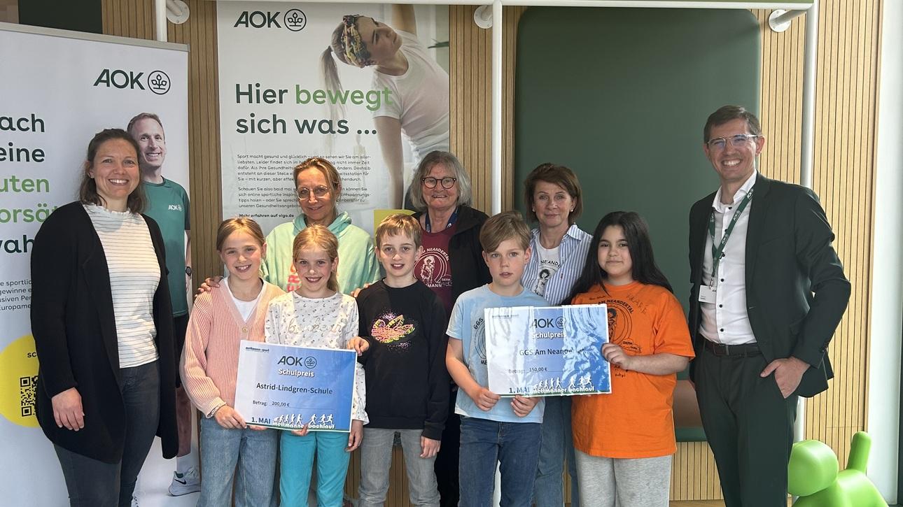 Gruppenfoto von Kindern und Erwachsenen in der Gesundheitsstation, alle halten Urkunden in den Händen.