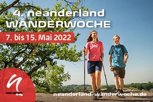 Zwei Wanderer auf einem Weg in der Natur, umgeben von Bäumen, mit Veranstaltungsdetails der Neanderland Wanderwoche.