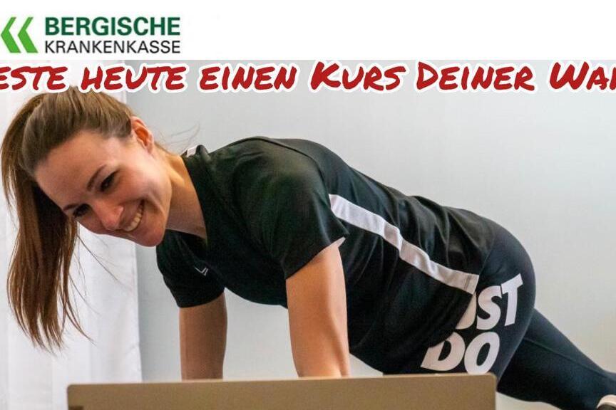 Junge Frau trainiert an einem Tisch, l&auml;chelt und liest eine Kursbeschreibung f&uuml;r einen Fitnesskurs.