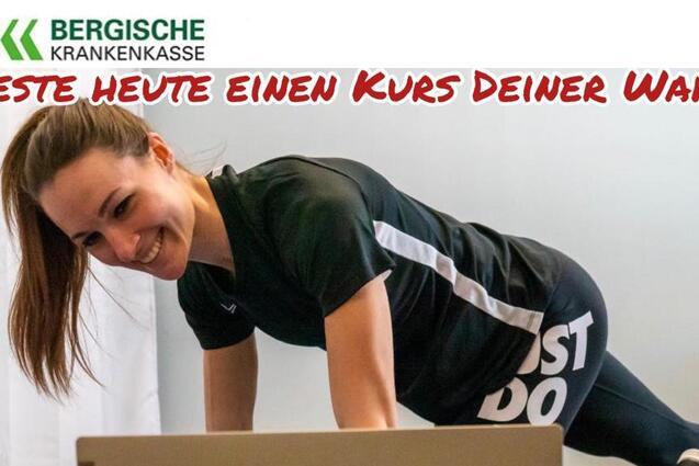 Junge Frau trainiert an einem Tisch, lächelt und liest eine Kursbeschreibung für einen Fitnesskurs.
