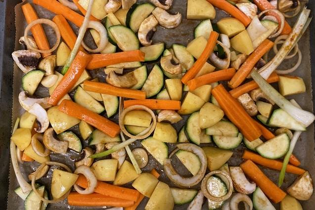 Blech mit gew&uuml;rfeltem Gem&uuml;se: Zucchini, Karotten, Kartoffeln, Zwiebeln und Champignons auf Backpapier.
