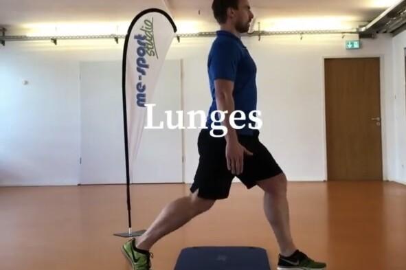 Mann in blauer Shirt führt eine Ausfallschrittübung auf einer Trainingsmatte in einem Fitnessraum aus.