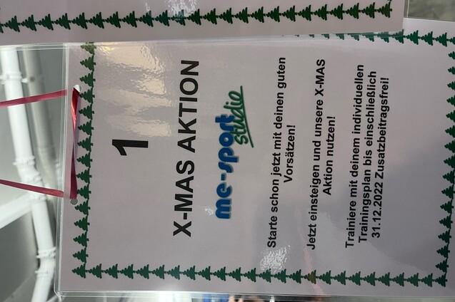 Informationsschild zur X-MAS Aktion mit Details zu Trainingsmöglichkeiten und Angeboten in einem Sportstudio.