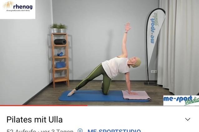 Frau in Pilates-Übung seitlich auf einer Matte, mit einem Arm nach oben gestreckt, Hintergrund mit Regalen.