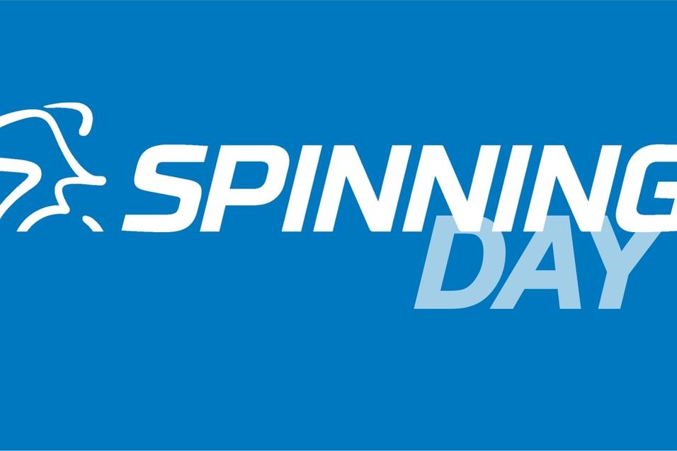 Logo mit dem Text „SPINNING DAY“ auf blauem Hintergrund, ergänzt durch eine stilisierte Darstellung eines Radfahrers.
