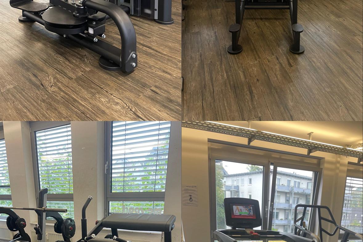 Fitnessstudio mit verschiedenen Trainingsgeräten, darunter eine Hantelbank, ein Rudergerät und ein Laufband.