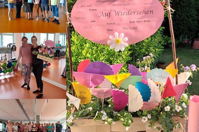 Gruppenfoto von Teilnehmern einer Veranstaltung mit einer dekorativen „Auf Wiedersehen“-Tafel und bunten Fähnchen auf Tisch.