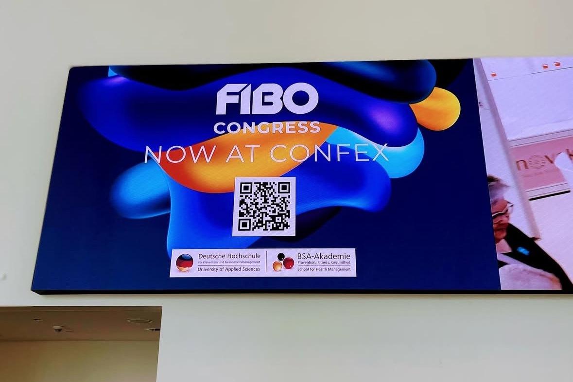 Digitales Anzeige-Bild für den FIBO Congress mit QR-Code und Informationen zur Deutschen Hochschule und BSA-Akademie.