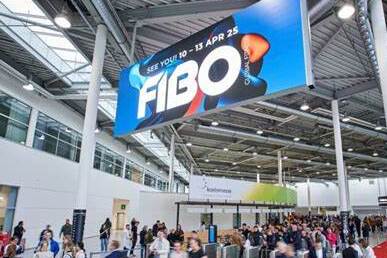 Menschenmenge vor einem gro&szlig;en FIBO-Werbeschild in einem modernen Messegeb&auml;ude.